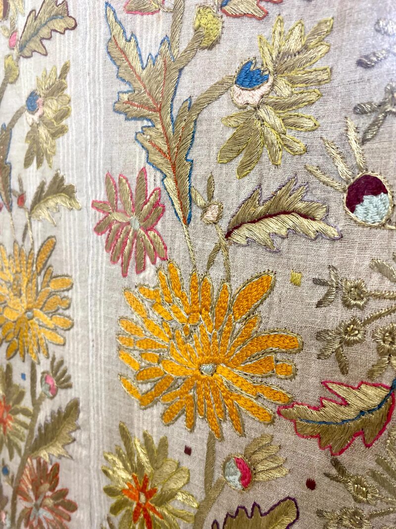 Close-up detail of antique Ottoman embroidery with gold thread and colorful floral motifs