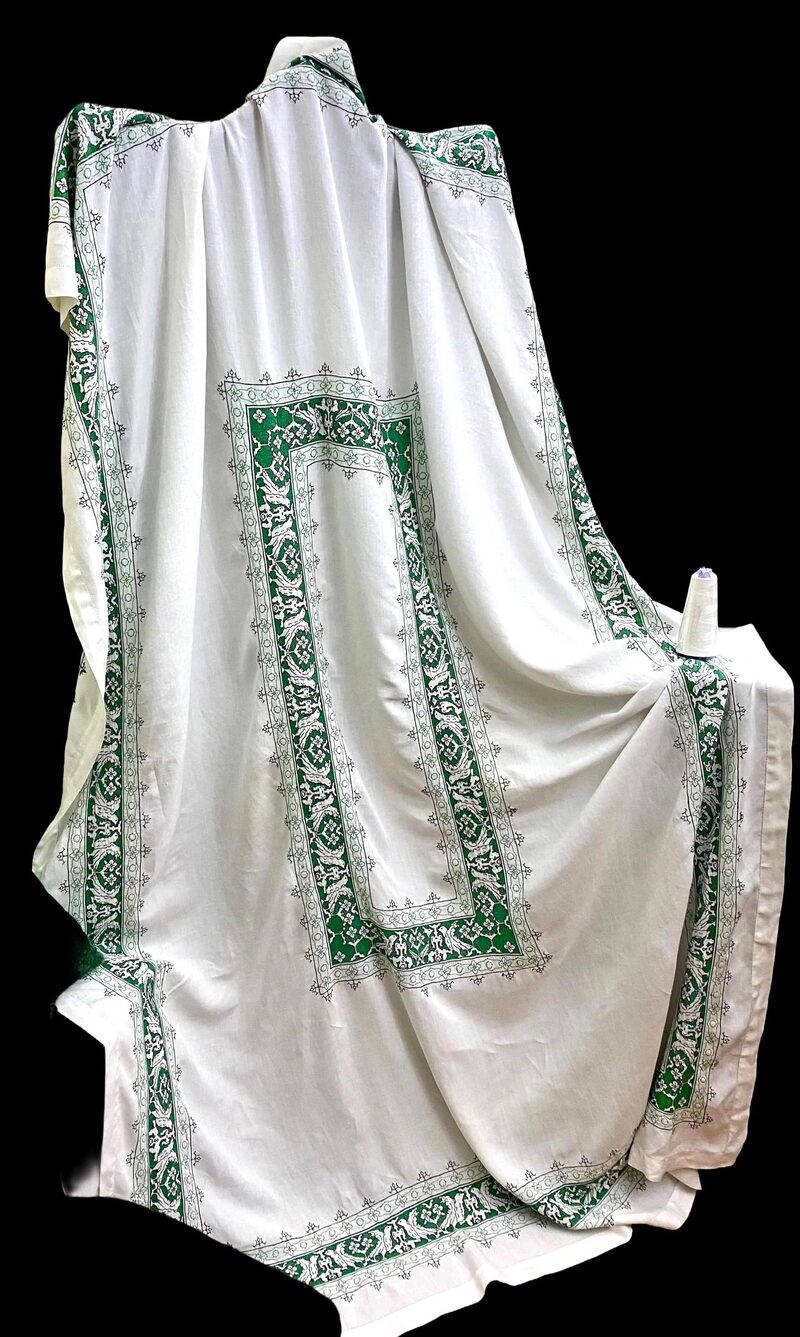 Antique white linen textile with green cross-stitch border pattern
